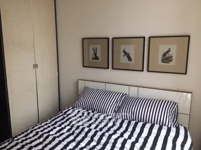 Cozy bedroom with striped bedding and elegant framed bird artwork