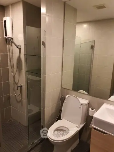 Modern bathroom with glass shower and sleek fixtures in a contemporary apartment.