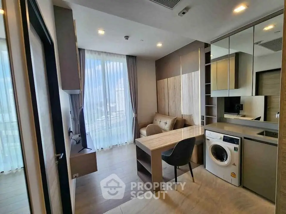 Modern living room with washing machine and stylish decor in high-rise apartment.