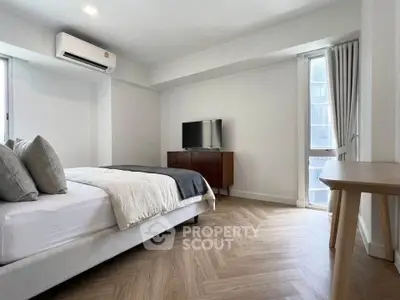 Spacious modern bedroom with stylish decor and natural light