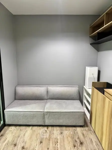Modern living room with sleek gray sofa and wooden flooring