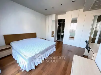 Spacious bedroom with wooden flooring and ample closet space