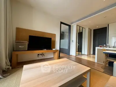 Modern living room with sleek wooden furniture and open kitchen layout.