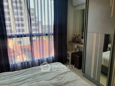 Cozy bedroom with large window and modern wardrobe in urban apartment