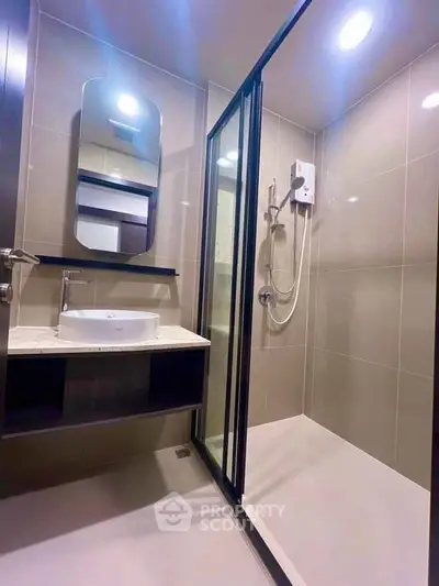 Modern bathroom with sleek shower enclosure and stylish vanity in contemporary apartment.