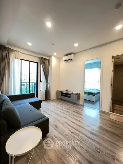 Spacious modern living room with wooden flooring and balcony view