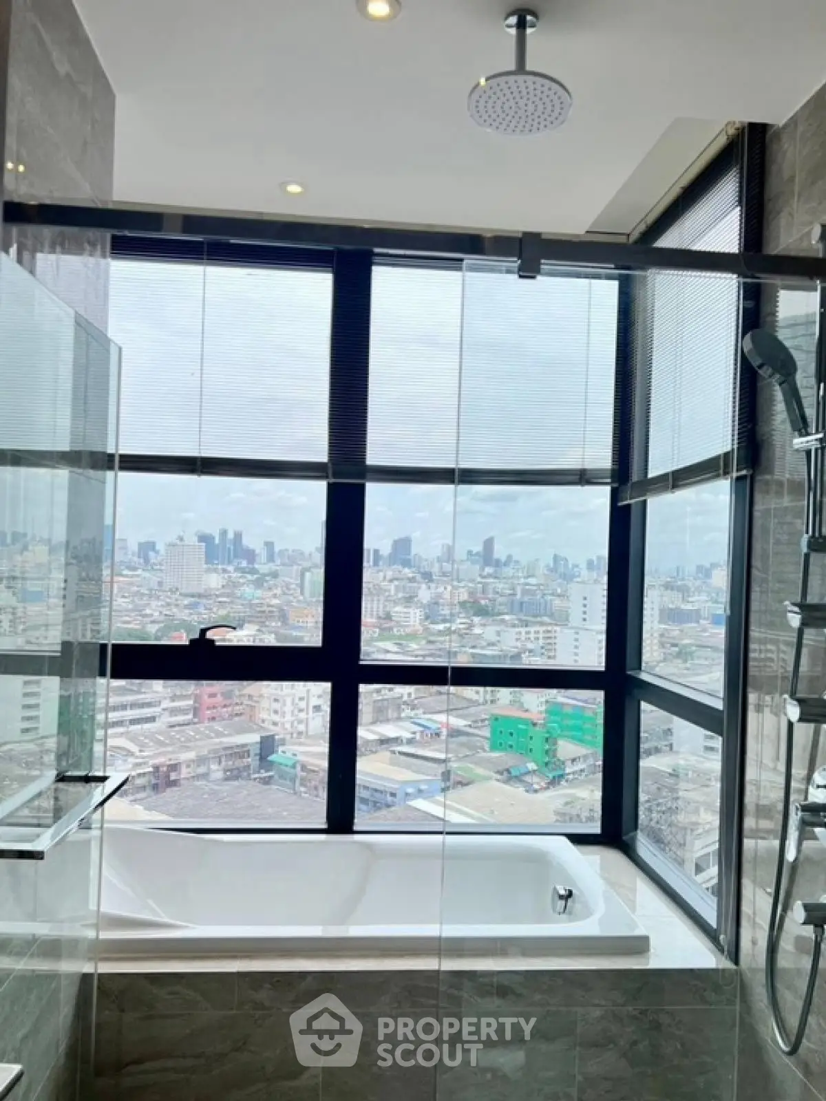 Luxurious bathroom with city view and modern bathtub in high-rise apartment.
