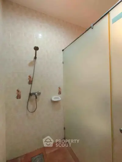 Cozy bathroom with shower and frosted glass partition in modern home.