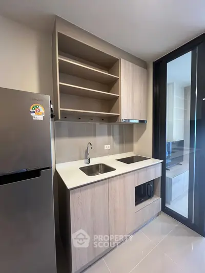 Modern compact kitchen with sleek cabinetry and built-in appliances in a stylish apartment.