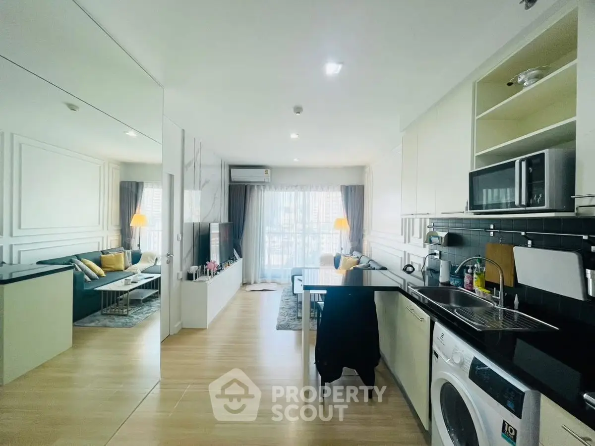Modern open-plan living room and kitchen with stylish decor and natural light.