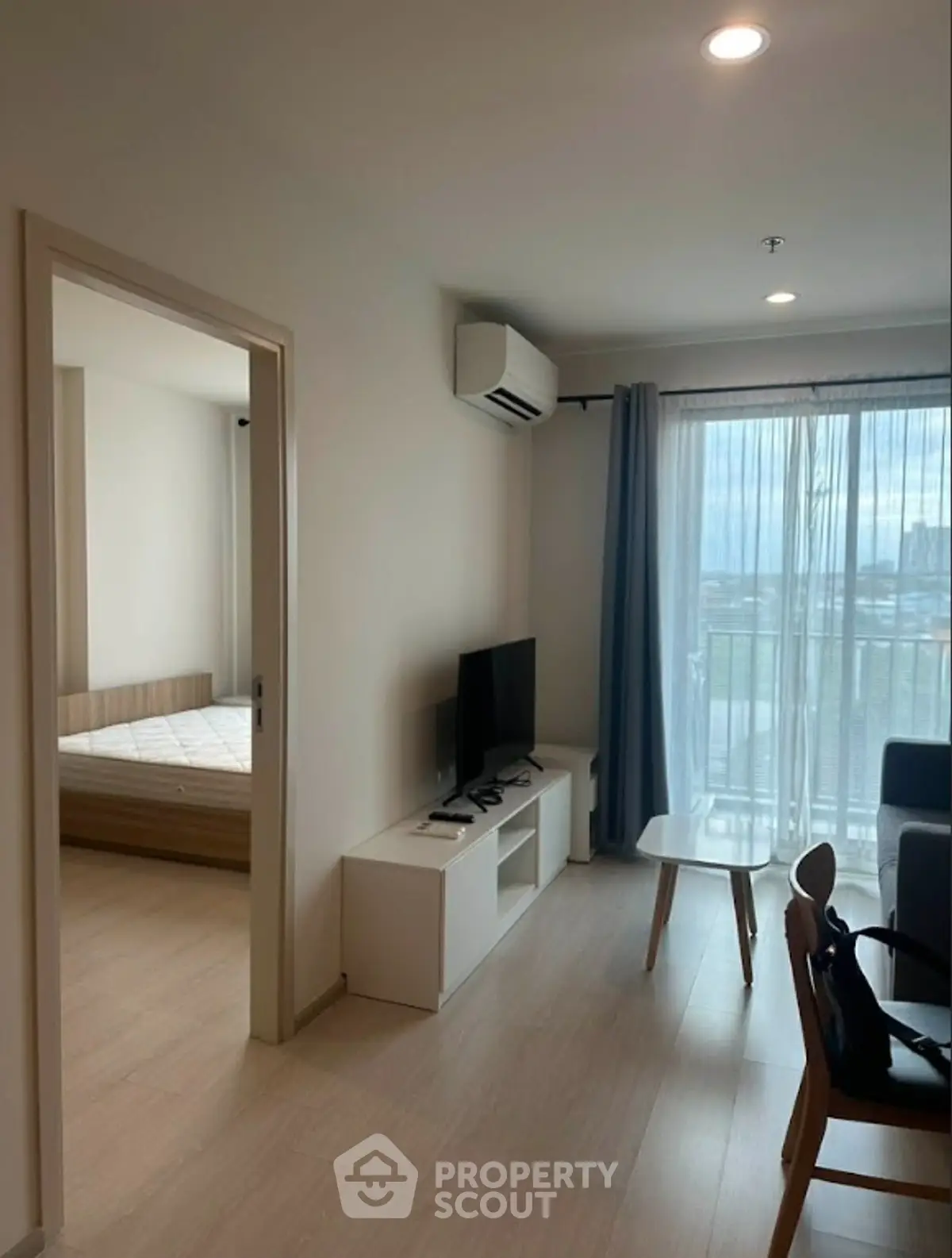 Modern living room with natural light, sleek furniture, and balcony view in a stylish apartment.