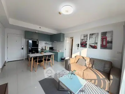 Modern living room with open kitchen, stylish decor, and ample natural light.