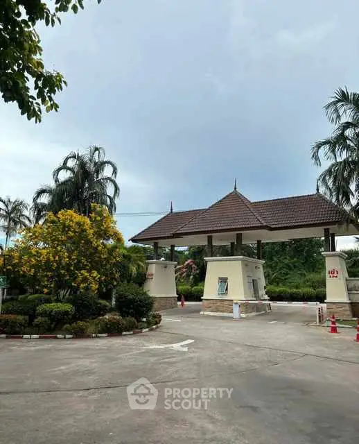 Charming gated entrance with lush landscaping and traditional architecture.
