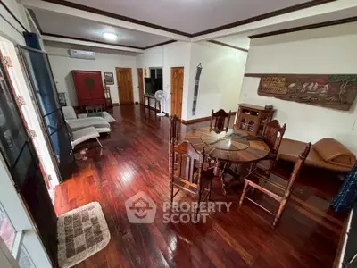 Spacious living room with wooden flooring and elegant dining area