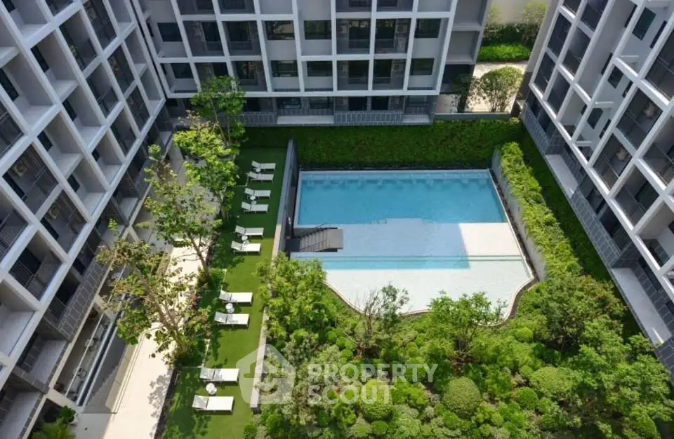 Luxurious condominium with a stunning pool and lush garden view, perfect for relaxation and leisure.