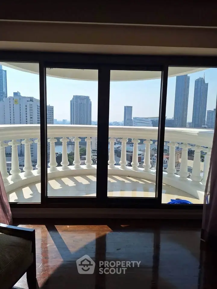 Luxurious high-rise apartment with stunning city view from large balcony.