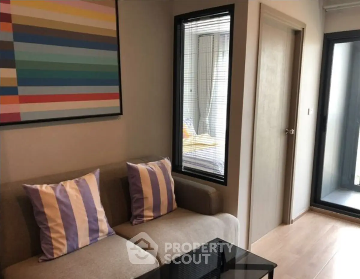 Modern living room with stylish decor and balcony access in a contemporary apartment.