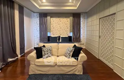 Luxurious bedroom with elegant decor and cozy seating area, featuring plush pillows and stylish wallpaper.