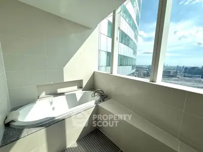 Luxurious bathroom with city view and modern bathtub in high-rise building.