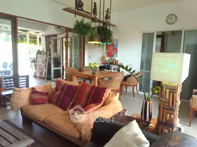 Spacious living room with cozy seating and natural light, perfect for relaxation and entertaining.