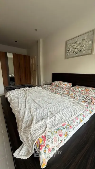 Spacious bedroom with modern decor and large bed, featuring a stylish wardrobe and elegant wall art.