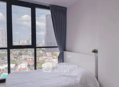 Bright bedroom with stunning city view from large windows in modern apartment.