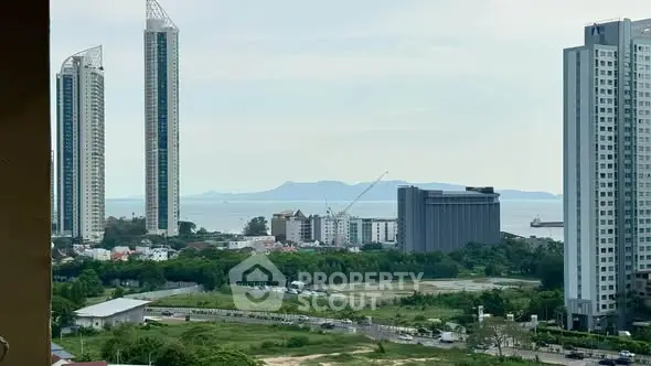 Stunning cityscape view with modern high-rise buildings and lush greenery near the coastline.