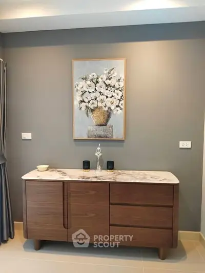 Elegant interior with stylish wooden sideboard and floral artwork, perfect for modern living spaces.