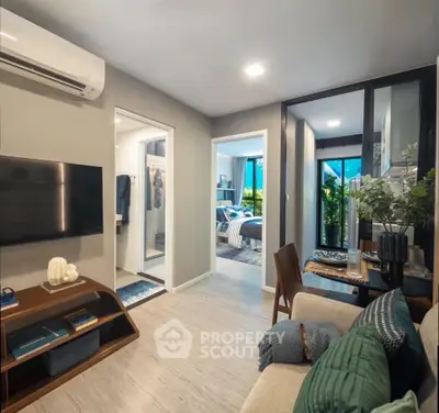Modern living room with open layout and stylish decor, featuring a cozy dining area and view into bedroom.