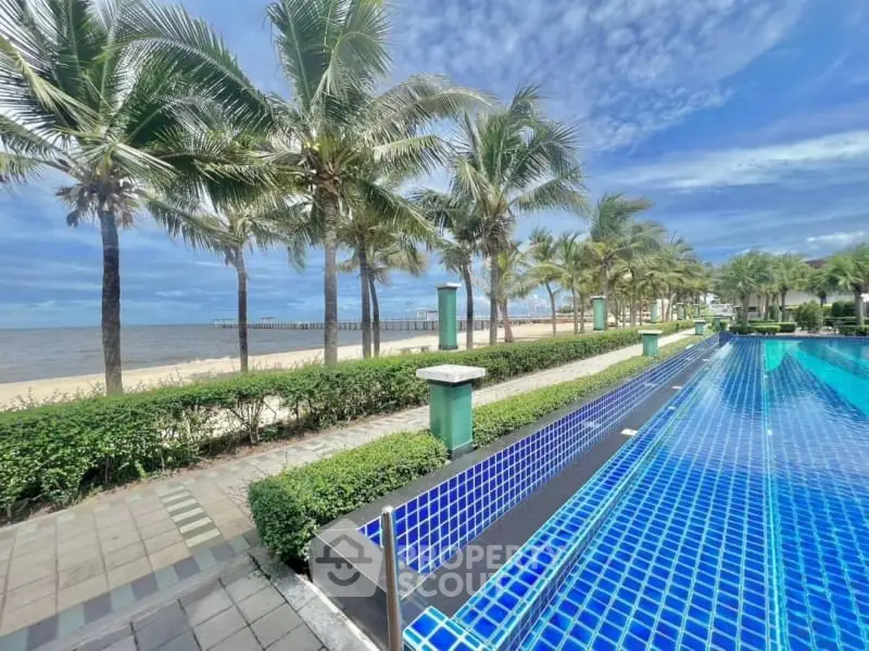 Stunning beachfront property with luxurious pool and palm-lined promenade.