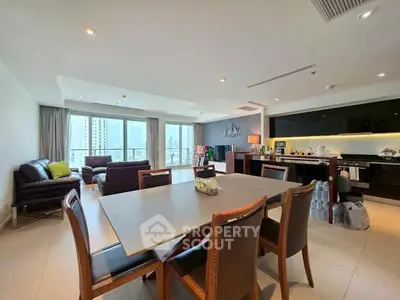 Spacious modern living room with open kitchen and city view, perfect for urban living.