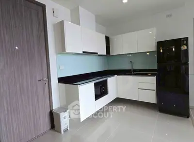 Modern kitchen with sleek white cabinets and black appliances