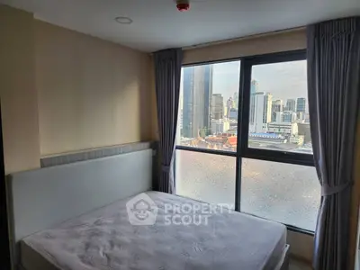 Modern bedroom with city view and large window in high-rise apartment