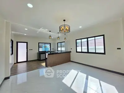 Spacious modern living room with open kitchen and elegant lighting fixtures