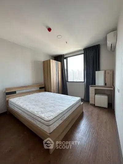 Spacious bedroom with modern furniture and natural light in a stylish apartment.