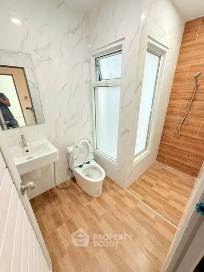 Modern bathroom with sleek design, featuring a walk-in shower and elegant fixtures.
