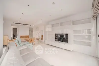 Spacious modern living room with sleek white furniture and built-in entertainment center.