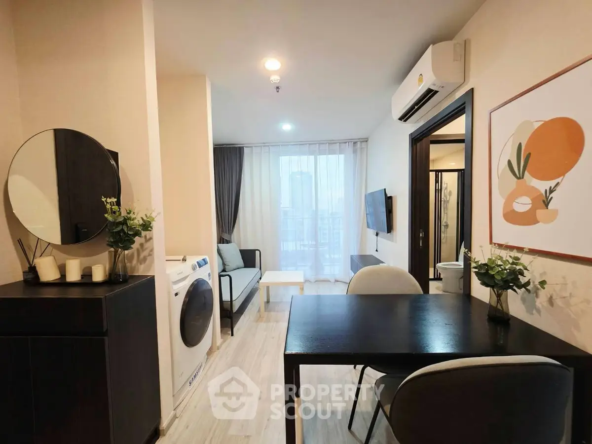 Modern living room with stylish decor and in-unit washing machine, perfect for urban living.