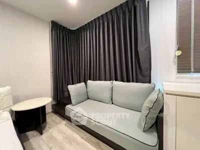 Cozy living room with modern sofa and elegant curtains, perfect for relaxation.