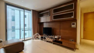 Modern living room with sleek wooden entertainment unit and large window view.