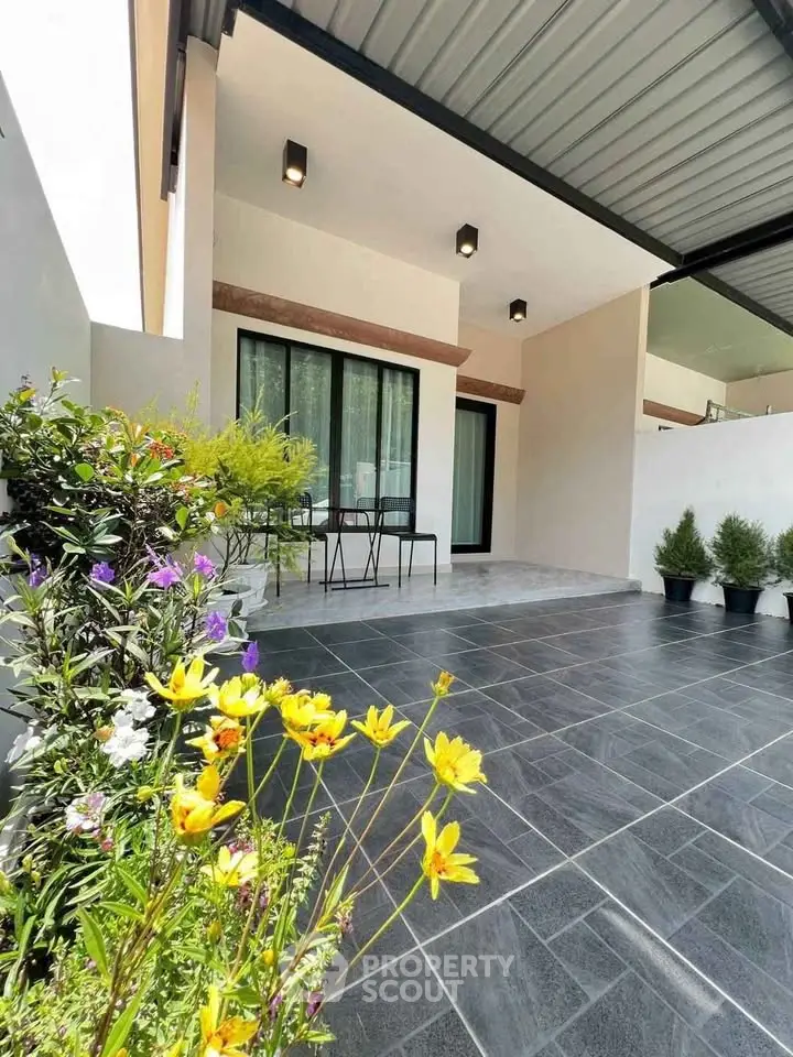 Modern home exterior with sleek patio and vibrant garden flowers