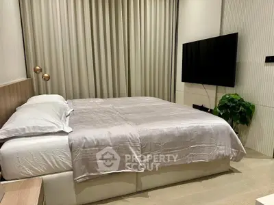 Modern bedroom with elegant decor and wall-mounted TV