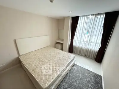 Spacious bedroom with large window and natural light in modern apartment.