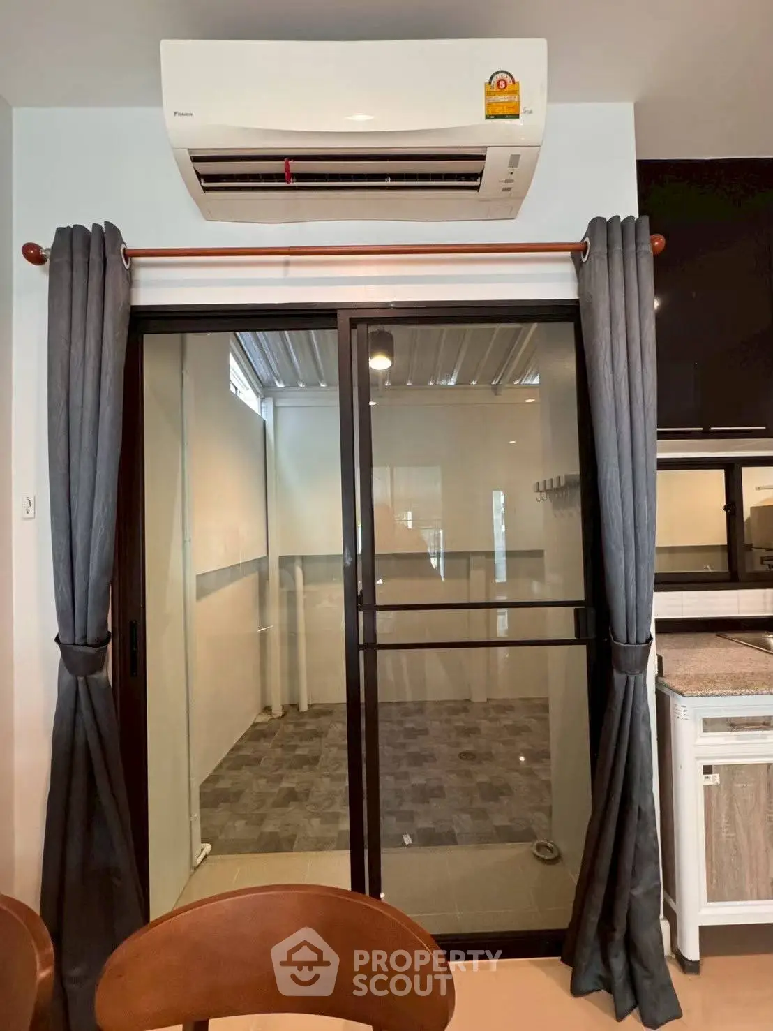Modern interior with sliding glass door and air conditioning unit, featuring sleek design and efficient space utilization.