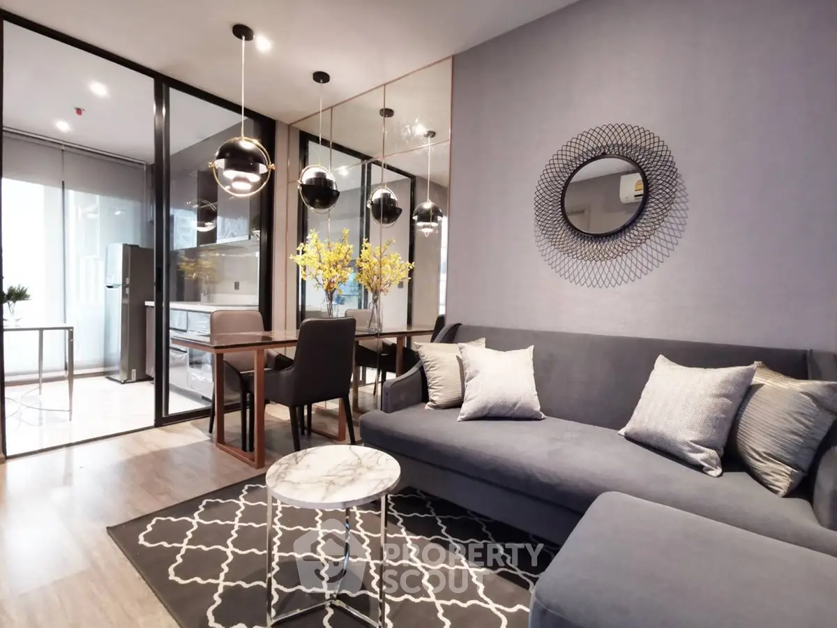 Modern living room with stylish decor, featuring a cozy sofa, elegant dining area, and contemporary lighting.