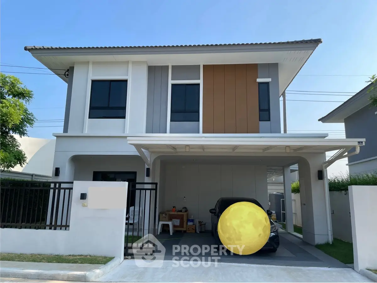 Modern two-story house with carport and sleek exterior design in a suburban neighborhood.