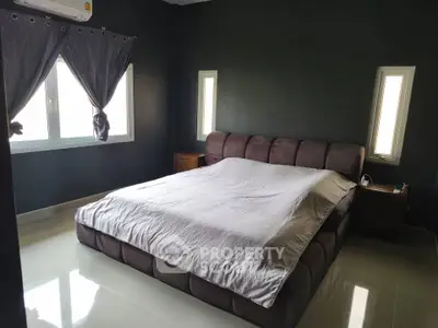 Spacious bedroom with modern decor and large windows for natural light