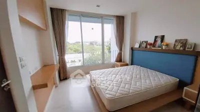 Spacious bedroom with large window and scenic view, featuring modern decor and ample natural light.