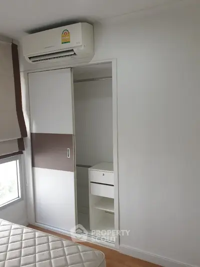 Compact bedroom with built-in closet and air conditioning unit