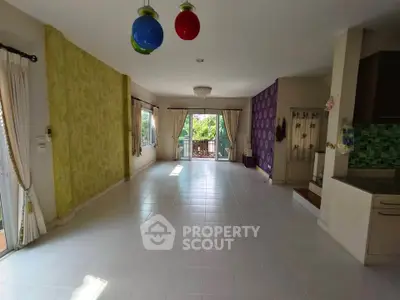 Spacious living room with large windows and colorful decor, perfect for family gatherings.